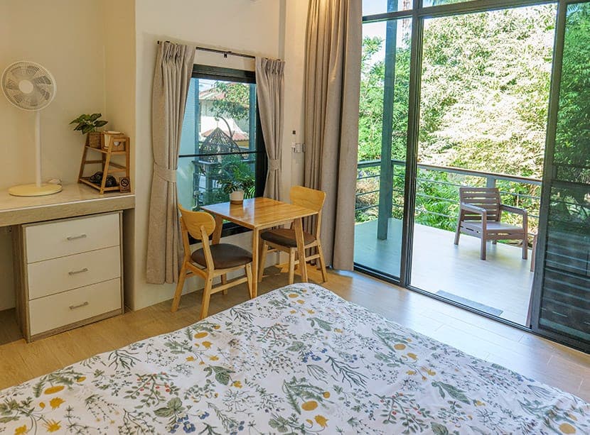 Bungalow interior with a table, chairs and doors onto the balcony