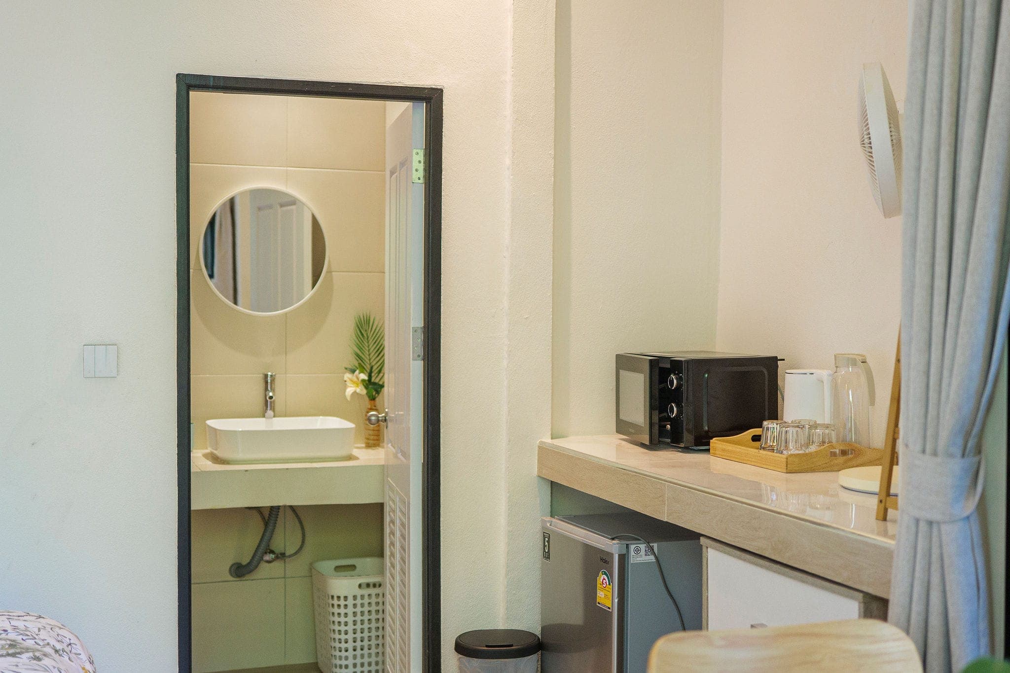 Kitchenette corner with a microwave, beside the bathroom mirror