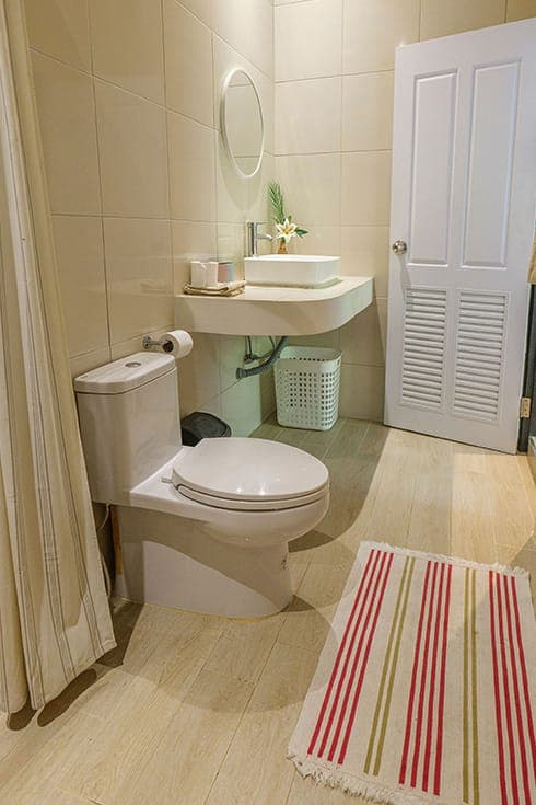 Modern Bungalow 3 — beige tiled bathroom with a round mirror