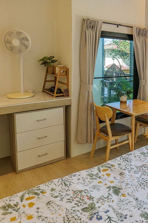 Modern Bungalow 3 — wooden table and chairs at the window, desk and drawers alongside
