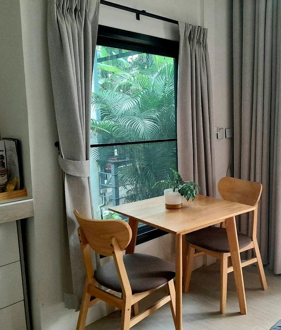 Dining table and chairs by the window, jungle outside