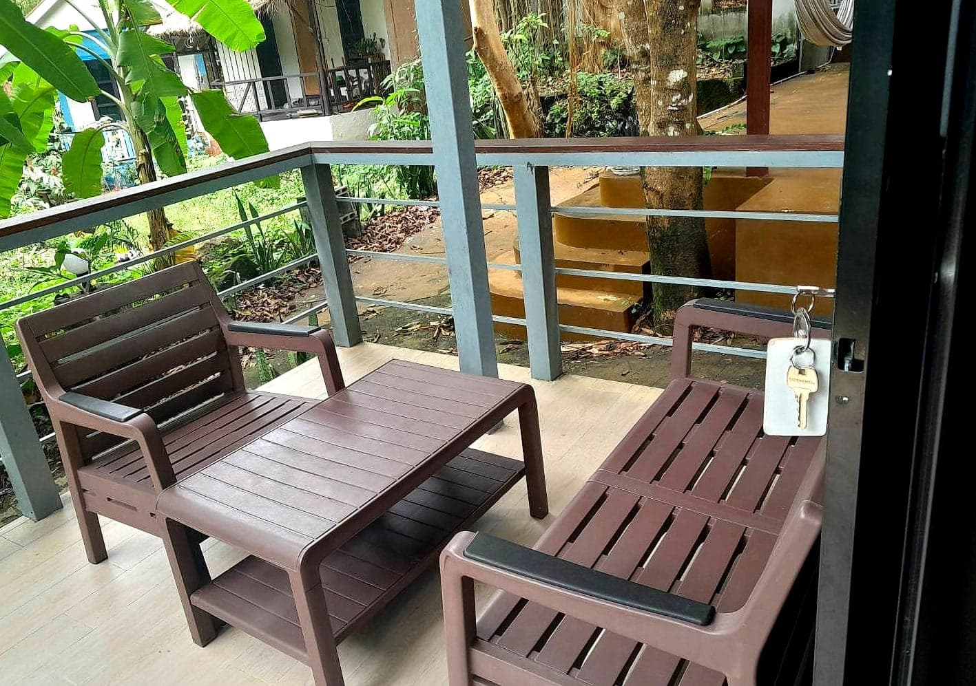 Private balcony with a table, bench and lounger among banana trees
